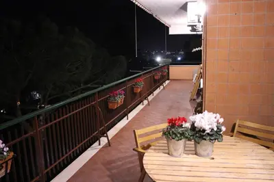 a balcony with a wooden table with flowers on it at Green view apartment in Rome