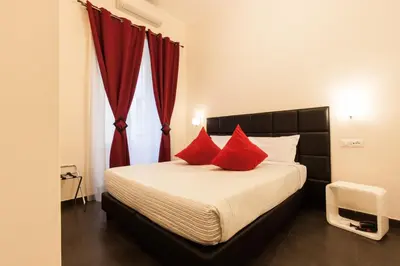 a bedroom with a bed with red pillows at Deko Rome in Rome