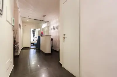 a hallway with white walls and a hallway with a table at Deko Rome in Rome