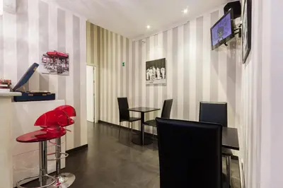 a waiting room with red chairs and a table at Deko Rome in Rome