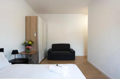 a bedroom with a bed and a black chair at St. Paul Palace Relais in Rome