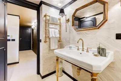 a bathroom with a sink and a tv on the wall at Luxurious loft facing the Pantheon in Rome