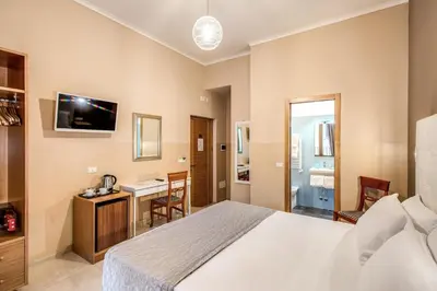 a hotel room with a bed and a desk at La Residenza Suites in Rome