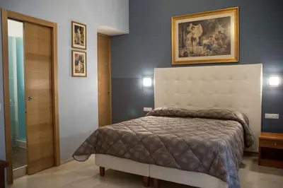 a bedroom with a bed and a painting on the wall at La Residenza Suites in Rome