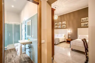 a bathroom with a sink and a bed in a room at La Residenza Suites in Rome