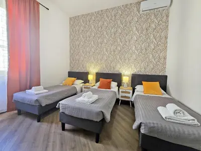 a room with three beds and two chairs at Myomax Guesthouse Hospety Group in Rome