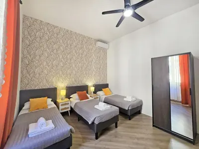 a hotel room with two beds and a ceiling fan at Myomax Guesthouse Hospety Group in Rome