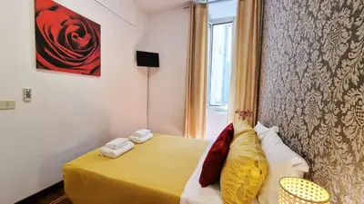 a small bedroom with a yellow bed and a window at Myomax Guesthouse Hospety Group in Rome