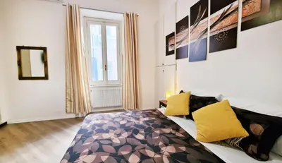 a bedroom with a bed with yellow pillows at Myomax Guesthouse Hospety Group in Rome