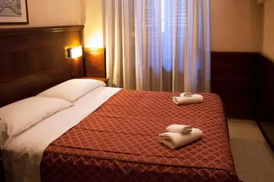a hotel room with a bed with two towels on it at Hotel Robinson in Rome