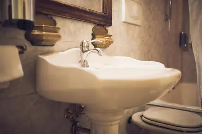 a white sink in a bathroom with a toilet at Hotel Robinson in Rome