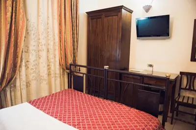 a bedroom with a bed and a desk and a television at Hotel Robinson in Rome