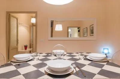 a dining room with a checkered table and chairs at GuestHost - Campo De' Fiori Central Flat in Rome