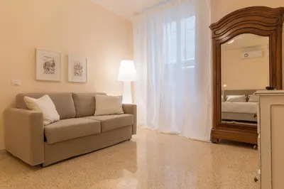 a living room with a couch and a mirror at GuestHost - Campo De' Fiori Central Flat in Rome