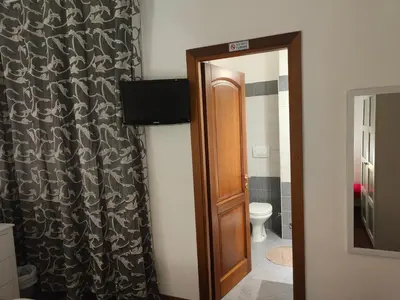 a bathroom with a toilet and a door with a mirror at AnnoDomini in Rome