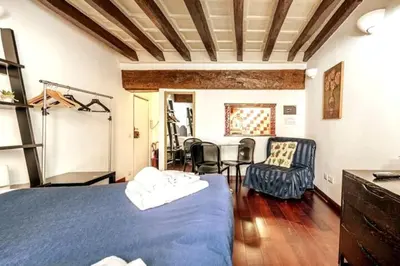 a bedroom with a blue bed and a table and chairs at Trastevere Apartments in Rome