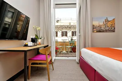 a hotel room with a bed and a desk and a window at Colonna 32 in Rome