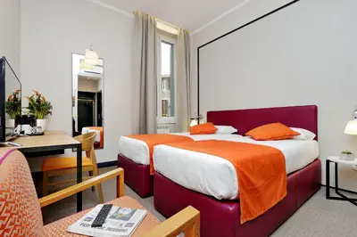 a hotel room with two beds and a desk at Colonna 32 in Rome