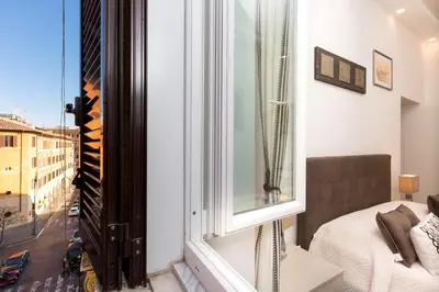 a room with a window with a bed and a view at Boutique Domus Trastevere Bertani in Rome