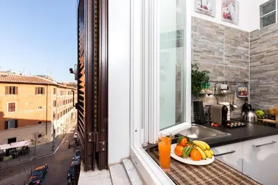 a plate of fruit on a table in a kitchen with a window at Boutique Domus Trastevere Bertani in Rome