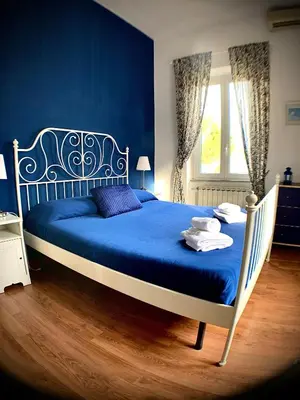 a blue bedroom with a large bed with blue sheets at Vatican Garden House in Rome