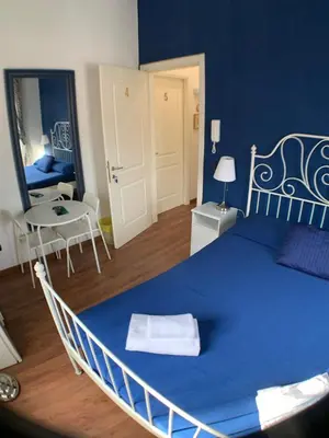 a large blue bed in a room with a table at Vatican Garden House in Rome