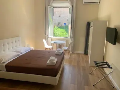 a bedroom with a bed and a table and a window at Vatican Garden House in Rome