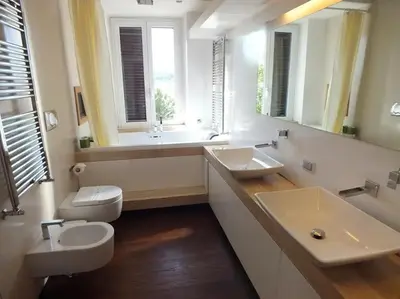 a bathroom with two sinks and a toilet and a mirror at Vatican Garden House in Rome