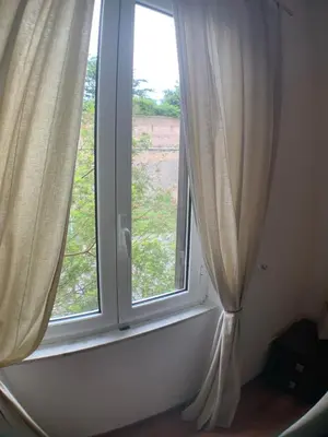a window with curtains and a view of a field at Vatican Garden House in Rome