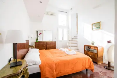 a bedroom with a bed with an orange blanket at Nice Apartment Navona Square in Rome