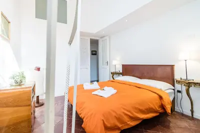 a bedroom with an orange bed with two towels on it at Nice Apartment Navona Square in Rome