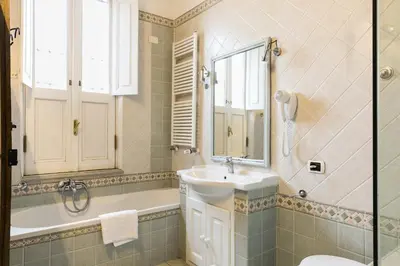 a bathroom with a sink and a tub and a mirror at Nice Apartment Navona Square in Rome
