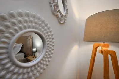 a mirror on a wall next to a lamp and a bed at Vicolo 22 - Residenze Romanae in Rome