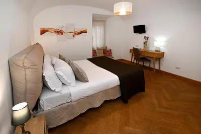 a bedroom with a bed and a desk and a table at Vicolo 22 - Residenze Romanae in Rome