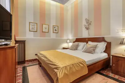 a bedroom with a bed and a flat screen tv at Spagna Dream Suites in Rome