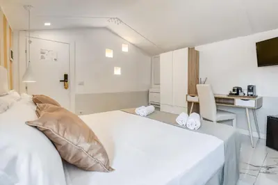 a bedroom with a white bed and a desk at Spagna Dream Suites in Rome