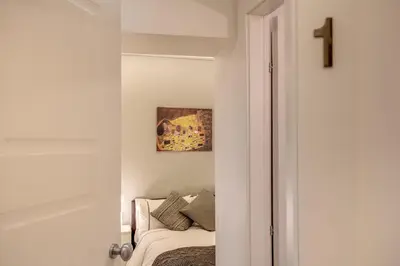 a white room with a bed and a cross on the wall at Dimore Costaguti in Rome