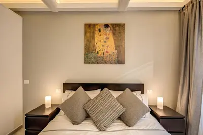 a bedroom with a bed with pillows and a painting on the wall at Dimore Costaguti in Rome