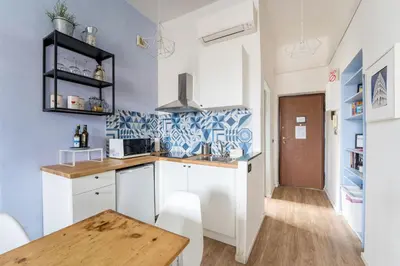 a kitchen with white cabinets and a wooden table at Trastevere Stylish in Rome