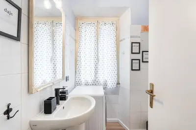 a white bathroom with a sink and a shower at Trastevere Stylish in Rome