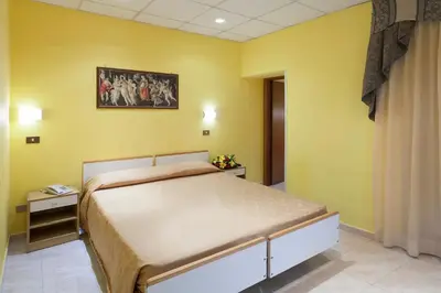 a bedroom with a large bed with yellow walls at Hotel Oriente in Rome
