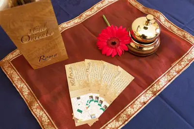 a table with a flower and a book on it at Hotel Oriente in Rome