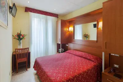 a bedroom with a red bed and a mirror at Hotel Oriente in Rome