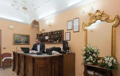 a man sitting at a reception desk with a computer at Hotel Oriente in Rome