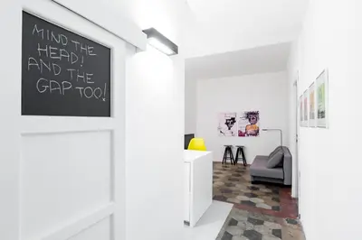 a room with a white wall with a sign on the door at Vicoloft Sales in Rome