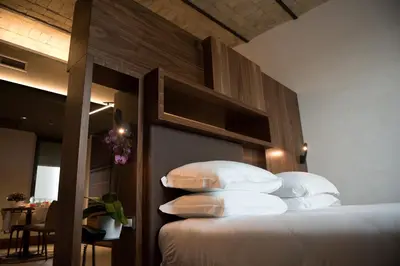 a bedroom with a large bed with white pillows at Gasometer Urban Suites in Rome