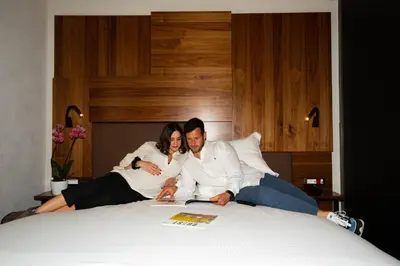 a man and a woman sitting on a bed at Gasometer Urban Suites in Rome