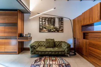 a living room with a green couch and a rug at Gasometer Urban Suites in Rome