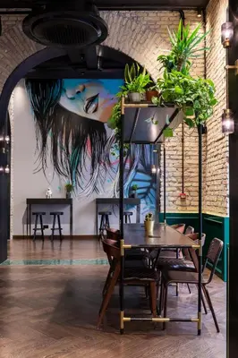 a dining room with tables and potted plants at Chapter Roma in Rome