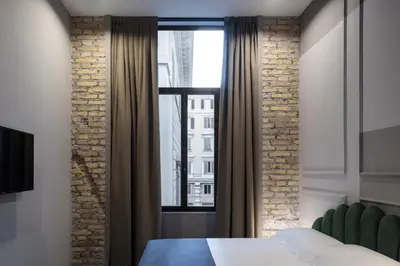 a bedroom with a large window and a green chair at Chapter Roma in Rome